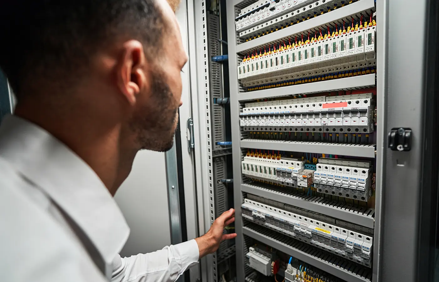 Mann schaut in den Schaltschrank