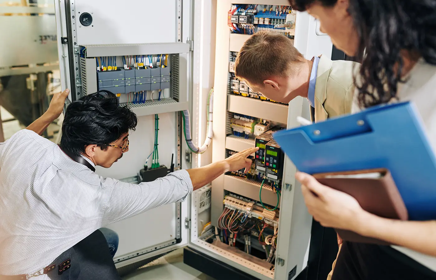 Mann zeigt etwas im Schaltschrank